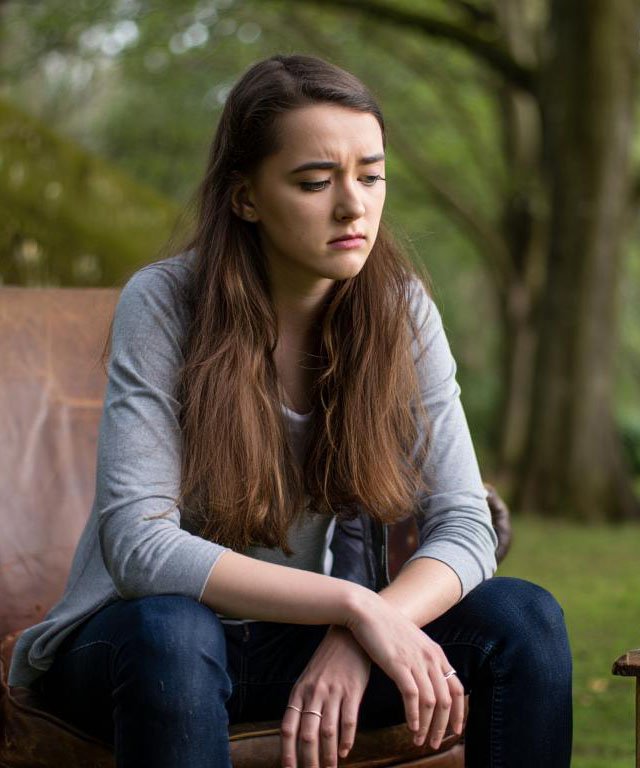 Девушка сиди на стуле в лесу